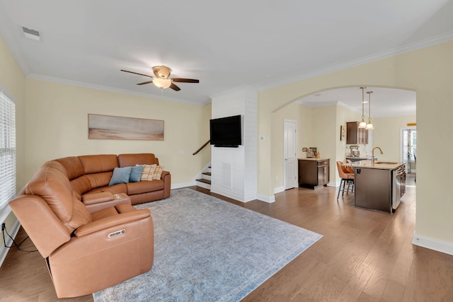 living room with ceiling fan, sink, crown molding, and dark hardwood / wood-style flooring