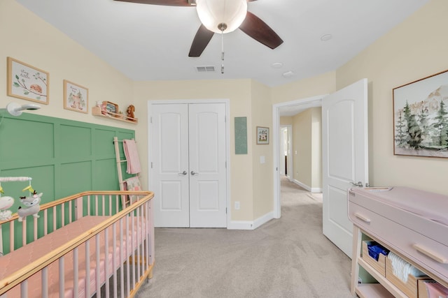 bedroom featuring ceiling fan, light colored carpet, and a closet