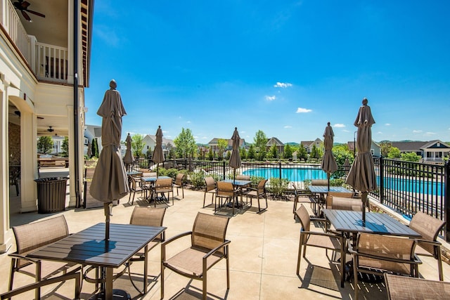 view of patio with ceiling fan and a community pool