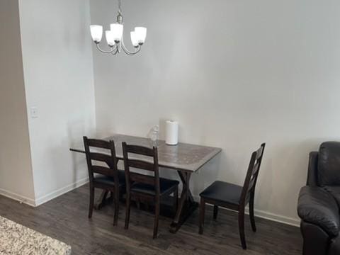 dining area with an inviting chandelier and dark wood-type flooring