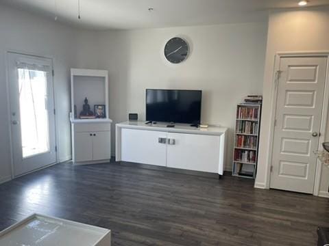 unfurnished living room with dark wood-type flooring and plenty of natural light