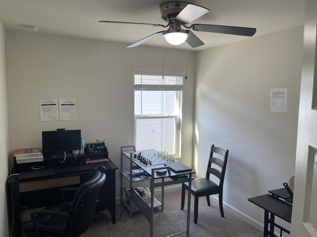 carpeted home office featuring ceiling fan