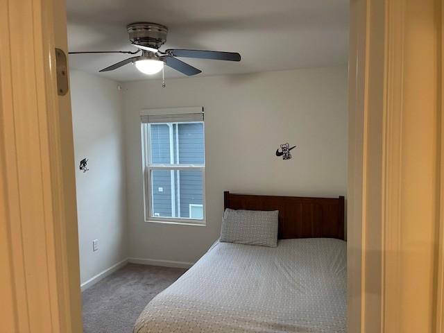 unfurnished bedroom with a ceiling fan, baseboards, and carpet flooring