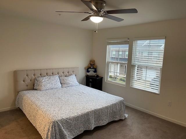 carpeted bedroom featuring ceiling fan and baseboards