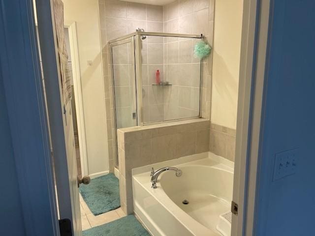 bathroom with a stall shower, a garden tub, and tile patterned floors