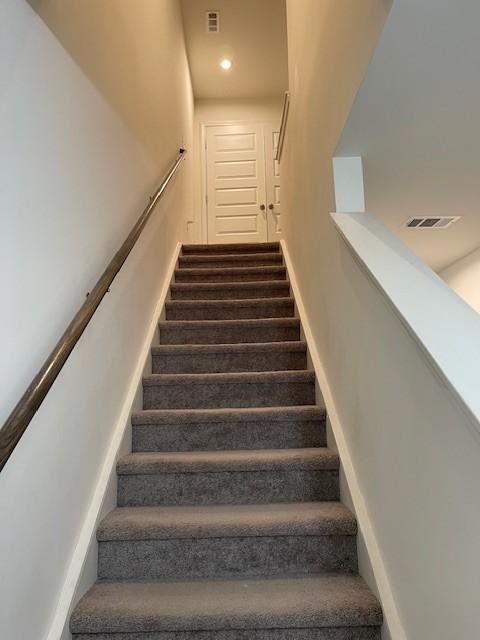 staircase featuring visible vents and baseboards