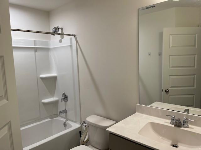 full bathroom featuring bathtub / shower combination, vanity, and toilet