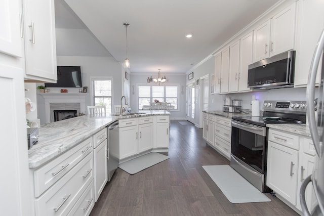 kitchen with stainless steel appliances, white cabinetry, sink, and kitchen peninsula