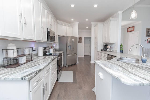 kitchen featuring sink, hanging light fixtures, stainless steel appliances, light stone countertops, and white cabinets