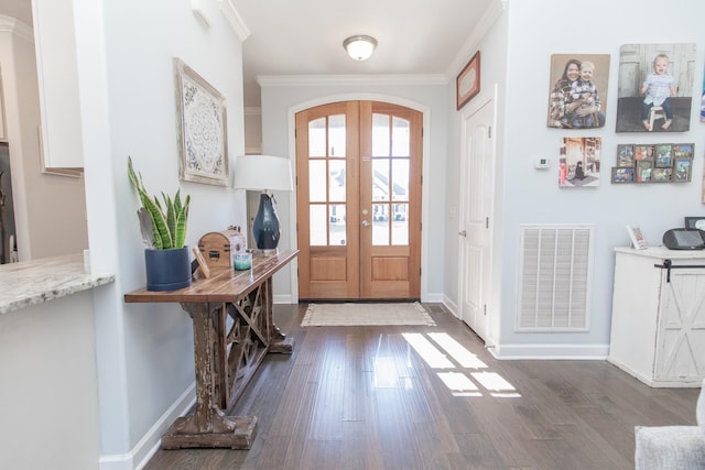 foyer with dark wood-type flooring, ornamental molding, and french doors