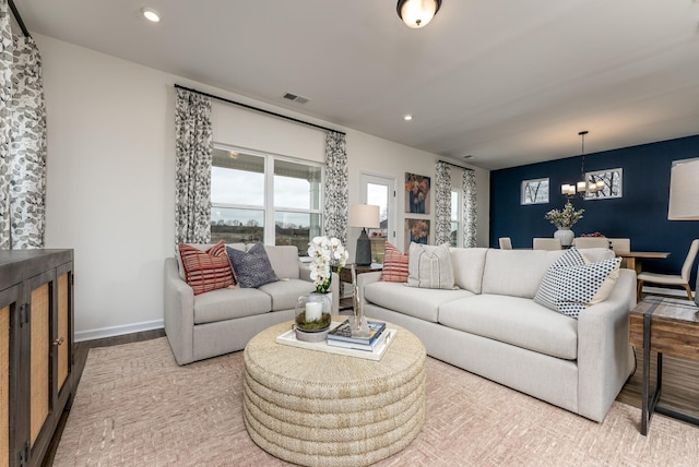 living room featuring a notable chandelier and light hardwood / wood-style flooring