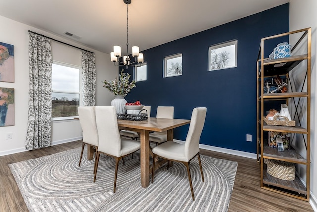 dining room with dark hardwood / wood-style floors and a notable chandelier