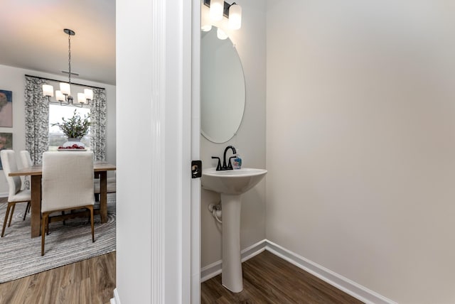 bathroom with hardwood / wood-style floors, a notable chandelier, and sink