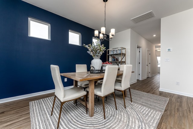 dining space featuring plenty of natural light, dark wood-type flooring, and a notable chandelier