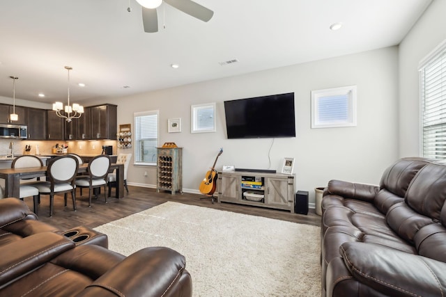 living room featuring plenty of natural light, dark hardwood / wood-style floors, and ceiling fan with notable chandelier