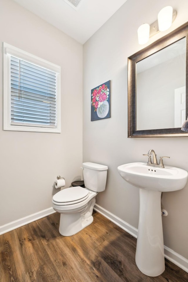 bathroom with hardwood / wood-style flooring, toilet, and sink