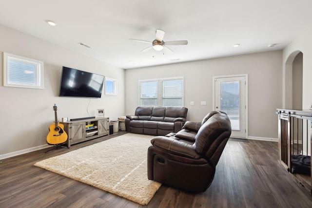 living room featuring dark wood-type flooring and ceiling fan