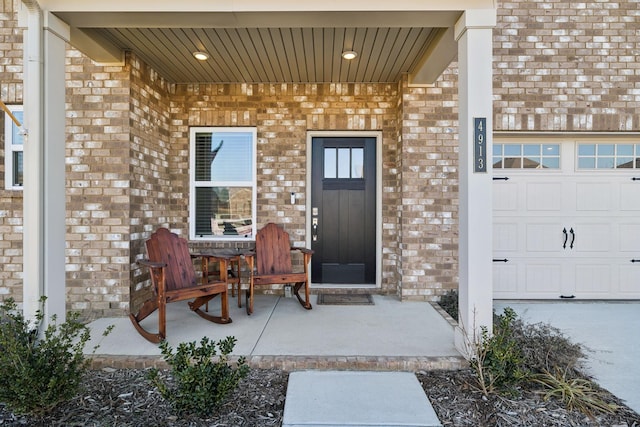 doorway to property featuring a garage and a porch