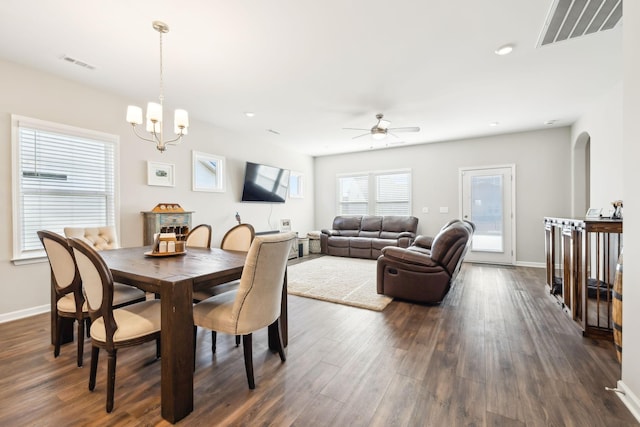 dining area with dark hardwood / wood-style flooring and ceiling fan with notable chandelier