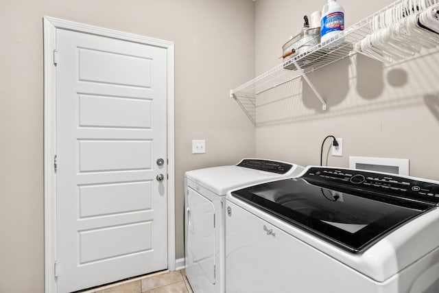 clothes washing area with light tile patterned flooring and independent washer and dryer