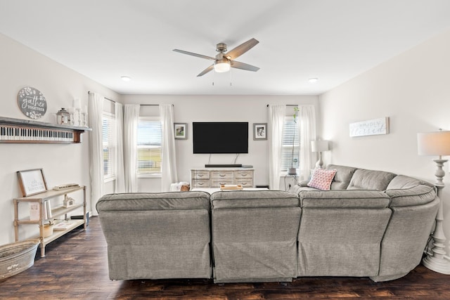 living room with dark wood-type flooring and ceiling fan