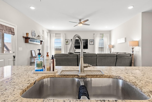 kitchen featuring light stone countertops, sink, a wealth of natural light, and ceiling fan