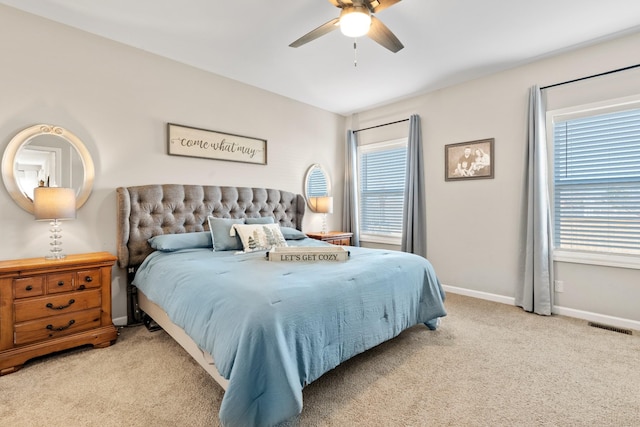 carpeted bedroom featuring multiple windows and ceiling fan