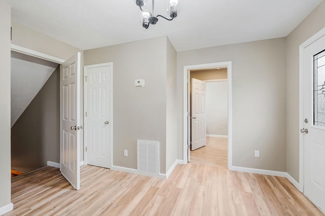 foyer entrance with a chandelier and light wood-type flooring