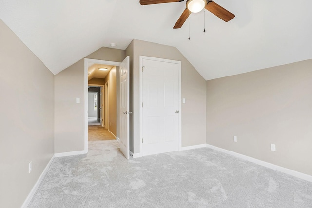 additional living space with vaulted ceiling, light colored carpet, and ceiling fan