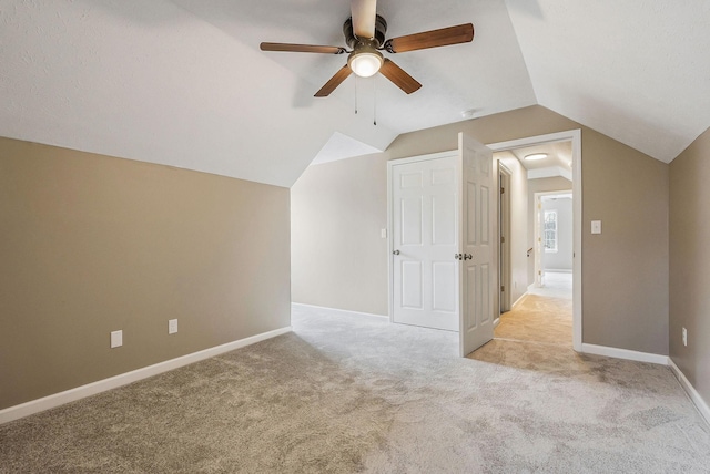 bonus room with lofted ceiling, light carpet, and ceiling fan