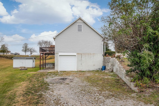 view of side of home featuring a wooden deck, a storage shed, a garage, and a yard