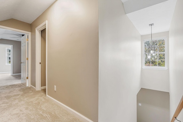 hall with light colored carpet and vaulted ceiling