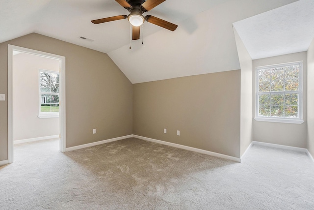 additional living space featuring lofted ceiling, light carpet, and ceiling fan