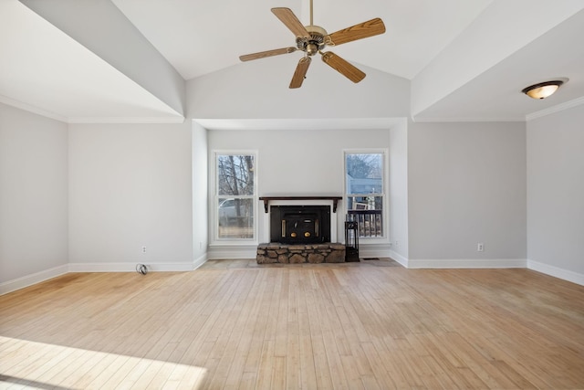 unfurnished living room with ceiling fan, a stone fireplace, vaulted ceiling, and light wood-type flooring