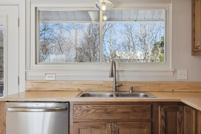 kitchen with butcher block countertops, sink, and stainless steel dishwasher