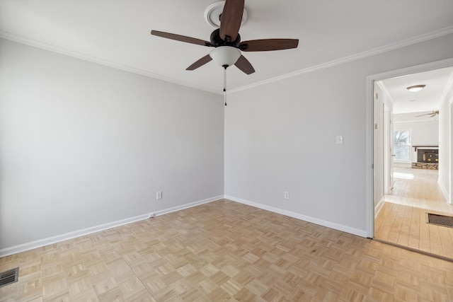 empty room featuring ceiling fan, ornamental molding, and light parquet floors