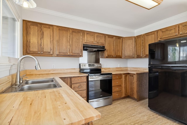 kitchen with sink, butcher block countertops, black fridge, stainless steel range with electric stovetop, and crown molding