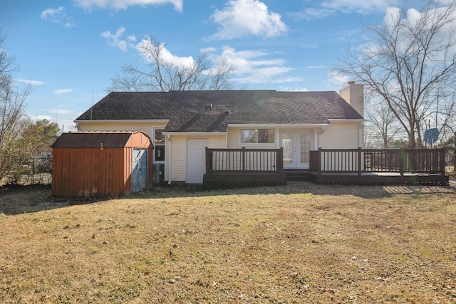 rear view of house featuring french doors, a wooden deck, a lawn, and a storage shed