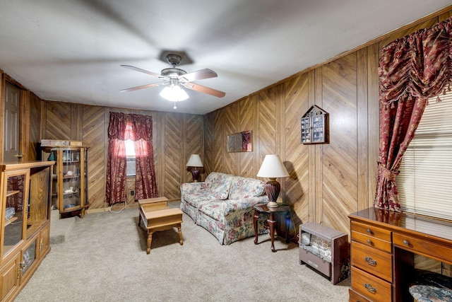 living room with light carpet, ceiling fan, and wood walls