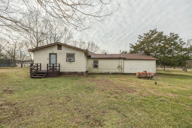 rear view of property featuring a yard and a trampoline