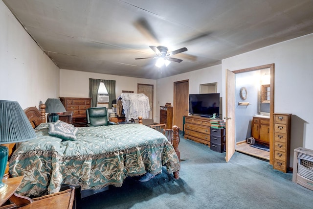 carpeted bedroom featuring heating unit, ceiling fan, and ensuite bathroom