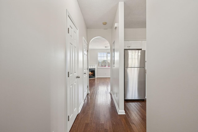 hall featuring a textured ceiling and dark hardwood / wood-style flooring