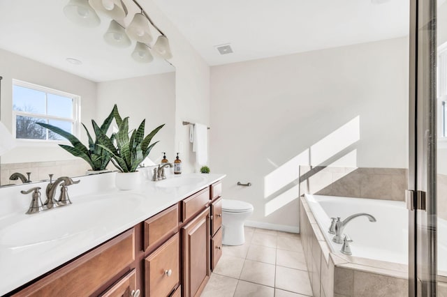 bathroom with toilet, vanity, tiled bath, and tile patterned flooring