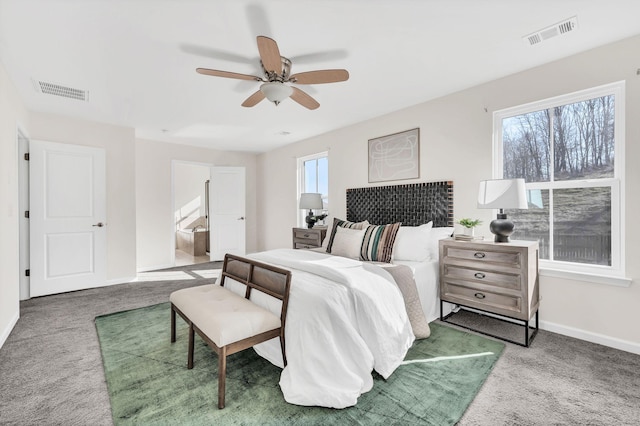 carpeted bedroom featuring ceiling fan and ensuite bath