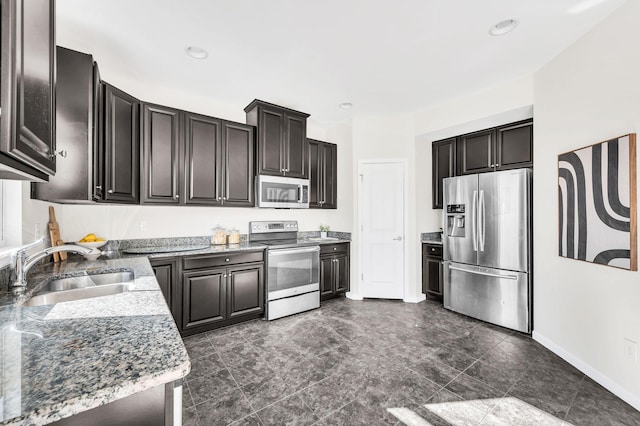 kitchen with appliances with stainless steel finishes, sink, and light stone counters