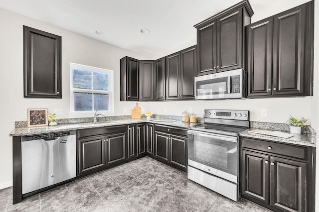 kitchen with stainless steel appliances, light stone countertops, and sink