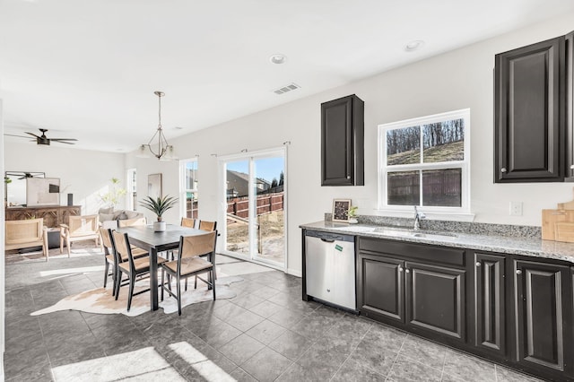 kitchen featuring sink, ceiling fan with notable chandelier, light stone counters, decorative light fixtures, and stainless steel dishwasher