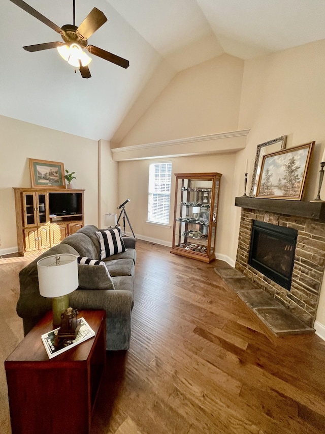 living room featuring high vaulted ceiling, a stone fireplace, hardwood / wood-style floors, and ceiling fan