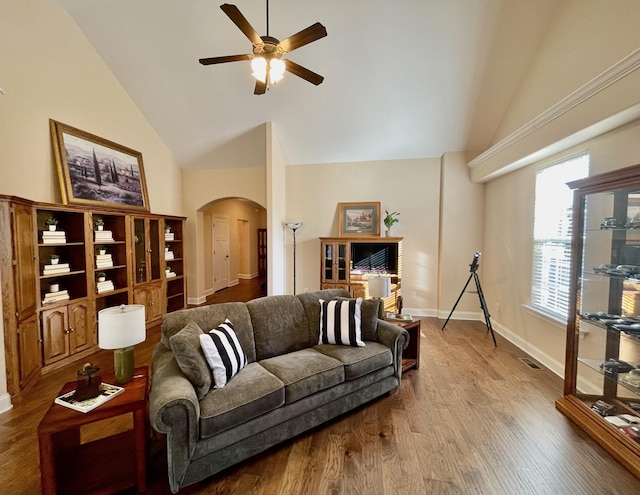 living room featuring hardwood / wood-style flooring, ceiling fan, and high vaulted ceiling