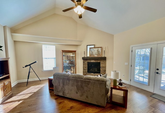 living room featuring ceiling fan, high vaulted ceiling, dark hardwood / wood-style floors, a fireplace, and french doors